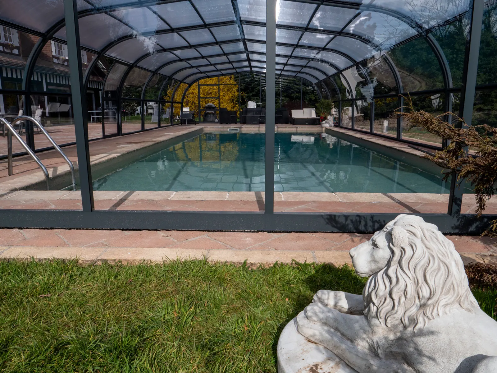 Un lion de pierre devant la piscine